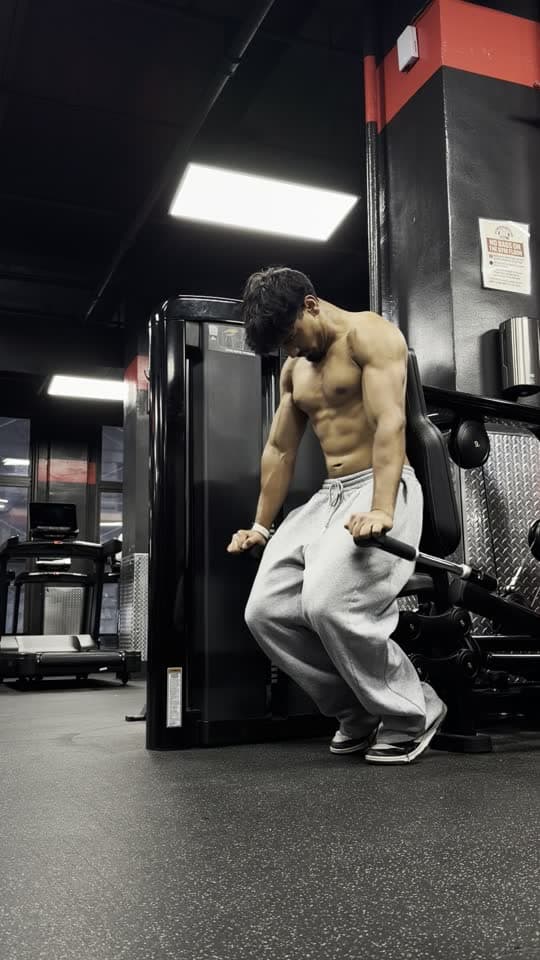 Raw phone clip of a man on a row machine in a dark gym