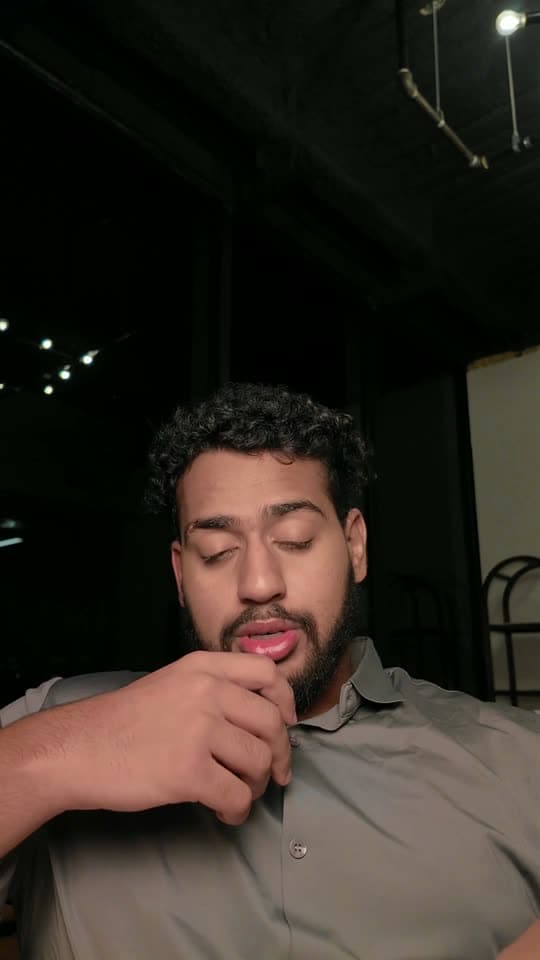 Raw selfie video of a man talking to camera in a dark room